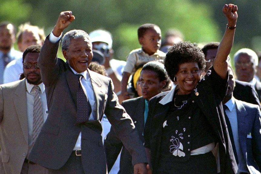 Nelson and Winnie Mandela hold hands and punch their fists in the air.