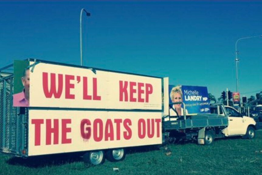 A sign on a trailer reads we'll keep the goats out, with the g obscuring a b