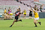 A Tiwi Bomber kicks around her body on TIO Stadium.