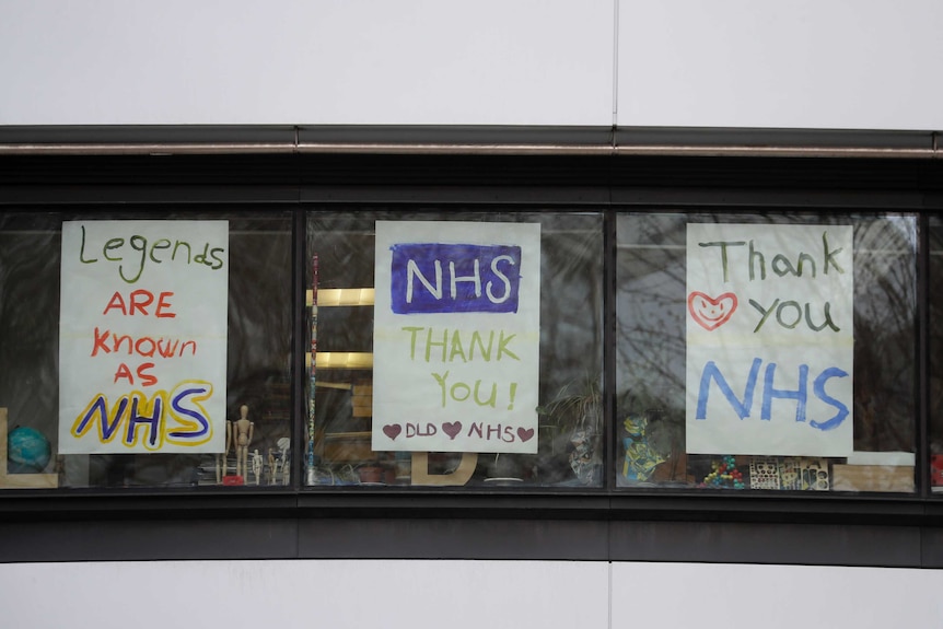 Hand drawn signs in a window read "Thank you NHS" and "Legends are known as NHS".
