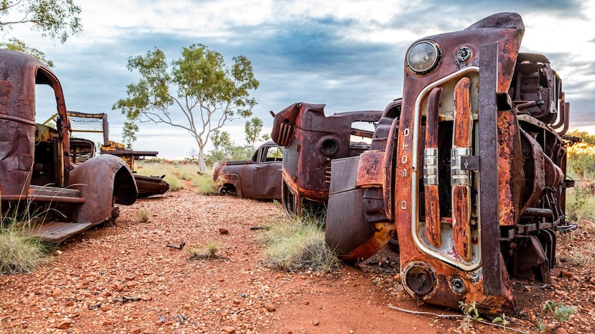 A vintage rusted truck lies on it's side