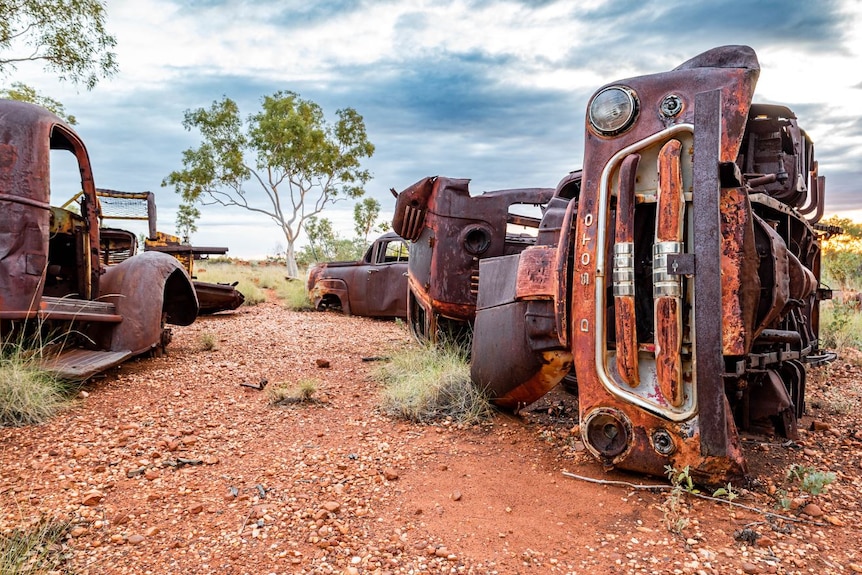 A vintage rusted truck lies on it's side