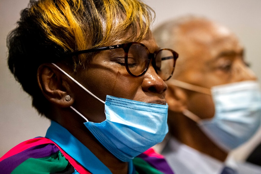 Ahmaud Arbery's mother is seen closing her eyes as verdict is read. She's wearing a mask and black gasses.