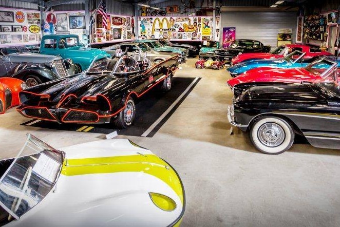 Looking down on rows of 1950s and 1960s classic American cars in a big shed.