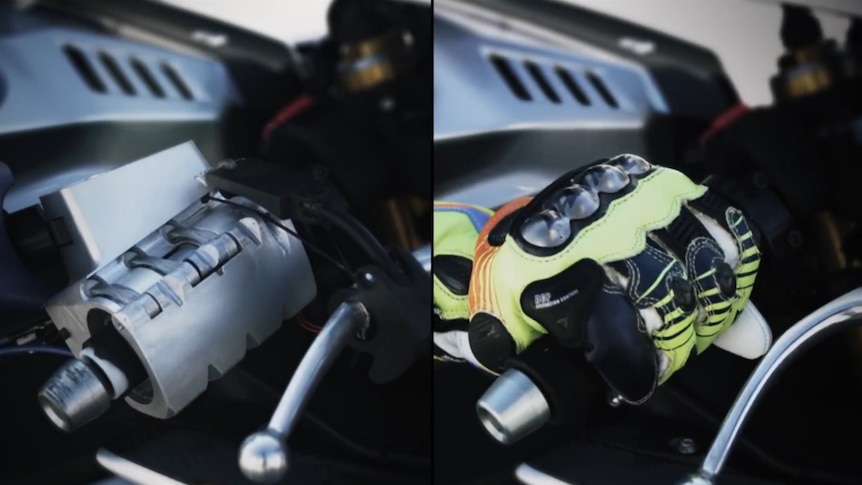 Video still showing MOTOBOT throttle hand next to Valentino Rossi's hand