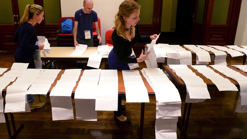 Electoral workers start counting the votes in the federal election.