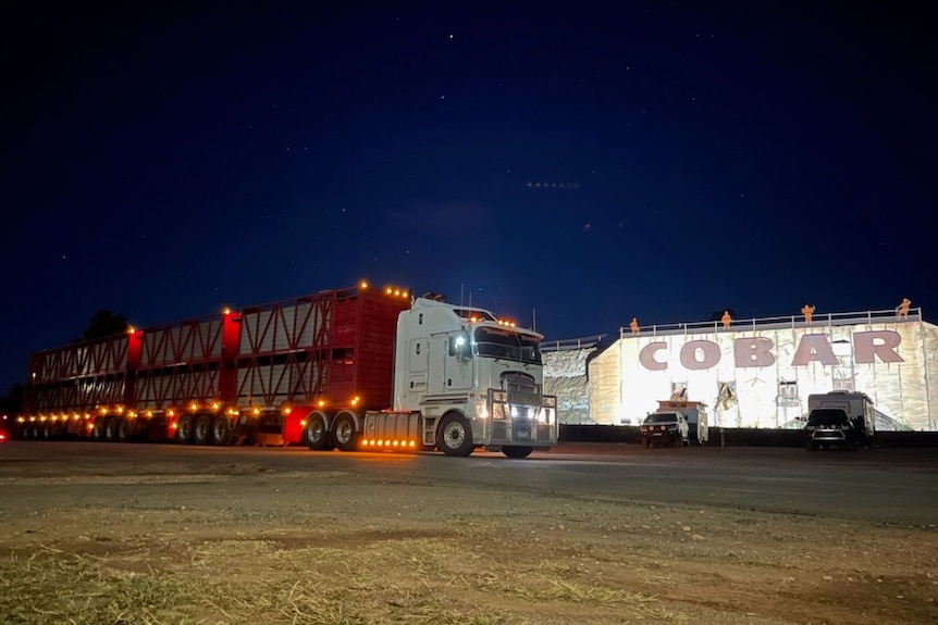 A road train truck parked infront of the sign for the town of Cobar, NSW