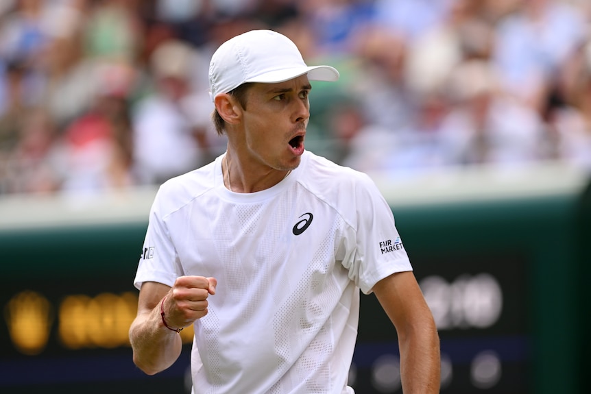 A man celebrates winning a tennis match