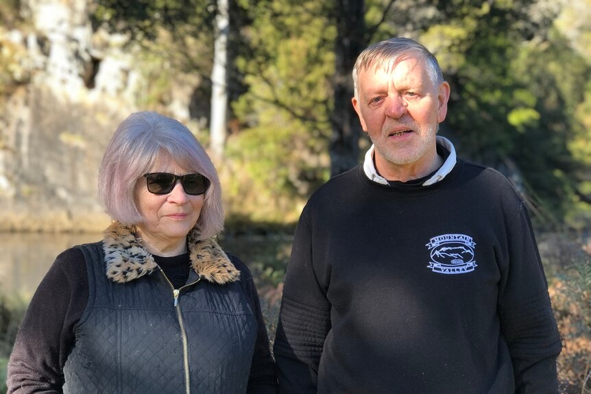 Tasmanian couple Pat and Len Doherty who own an accommodation business standing together with trees in the background