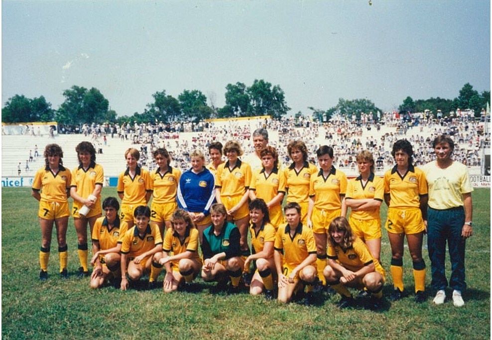 Um grupo de jogadoras de futebol em ouro e verde