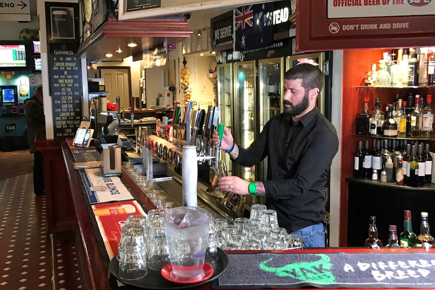 Adam D'Aprano pours a beer at The Oxford Scholar pub.