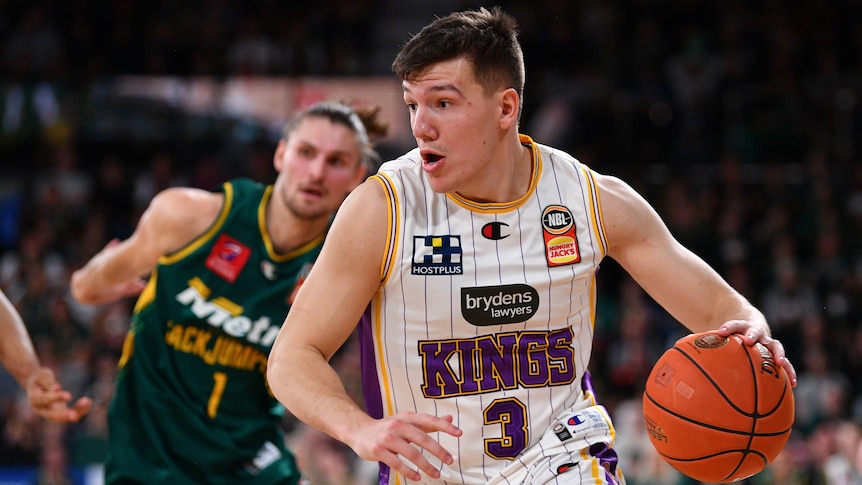 A Sydney Kings NBL player drives to the basket against the Tasmania JackJumpers.