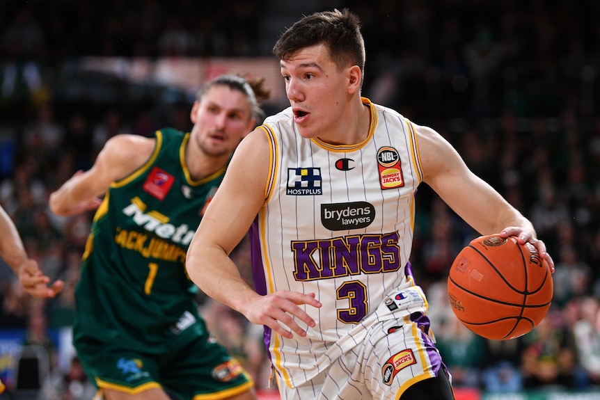 A Sydney Kings NBL player drives to the basket against the Tasmania JackJumpers.