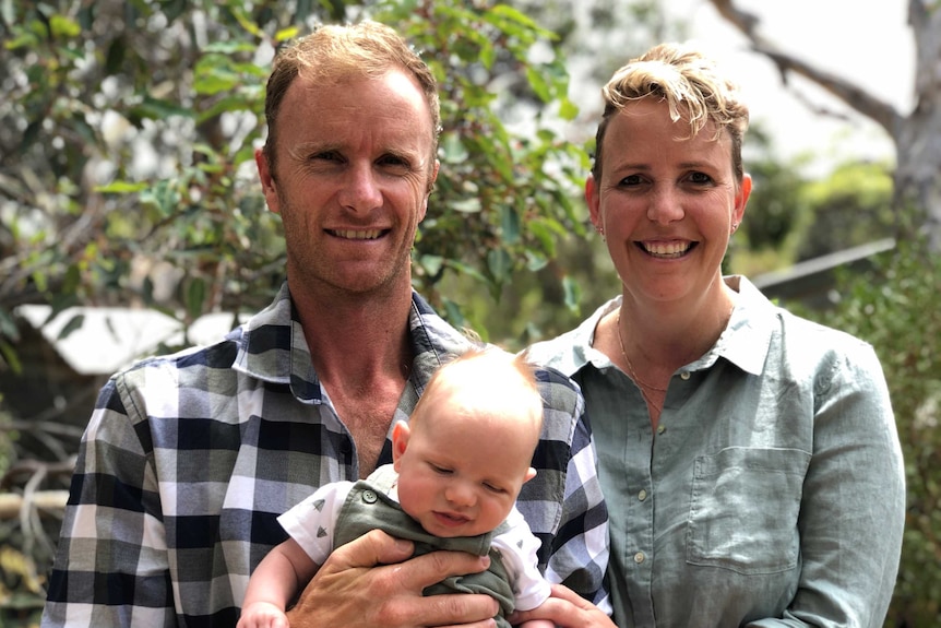 A man and a woman holding a baby