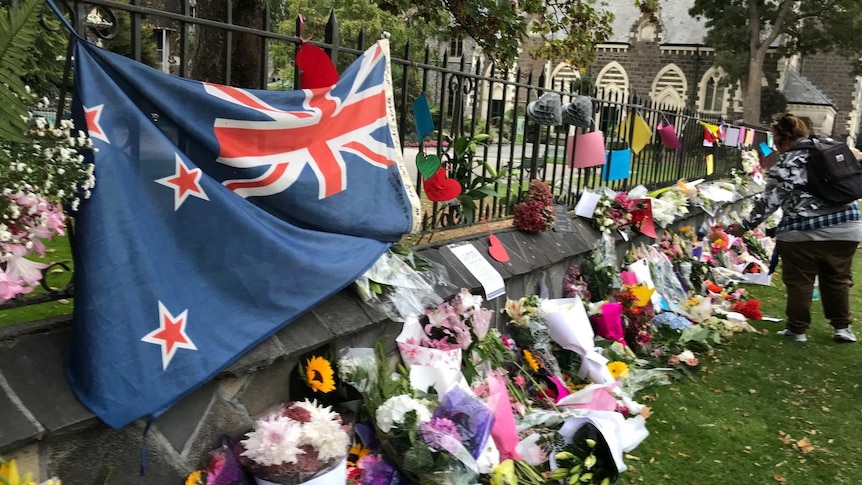 Flowers and a New Zealand flag are draped along the boundary of the Al Noor mosque.