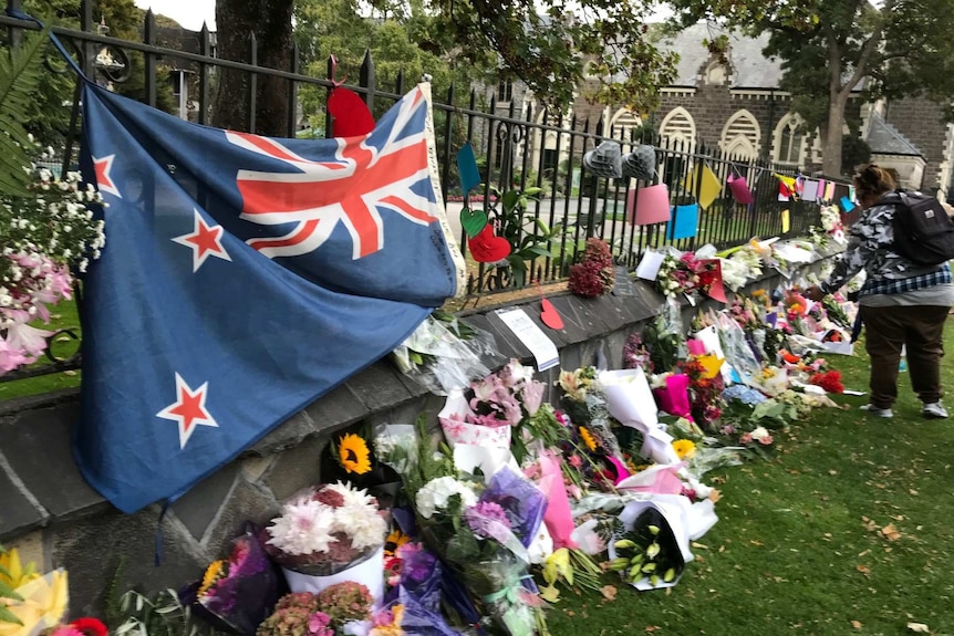Flowers and a New Zealand flag are draped along the boundary of the Al Noor mosque.