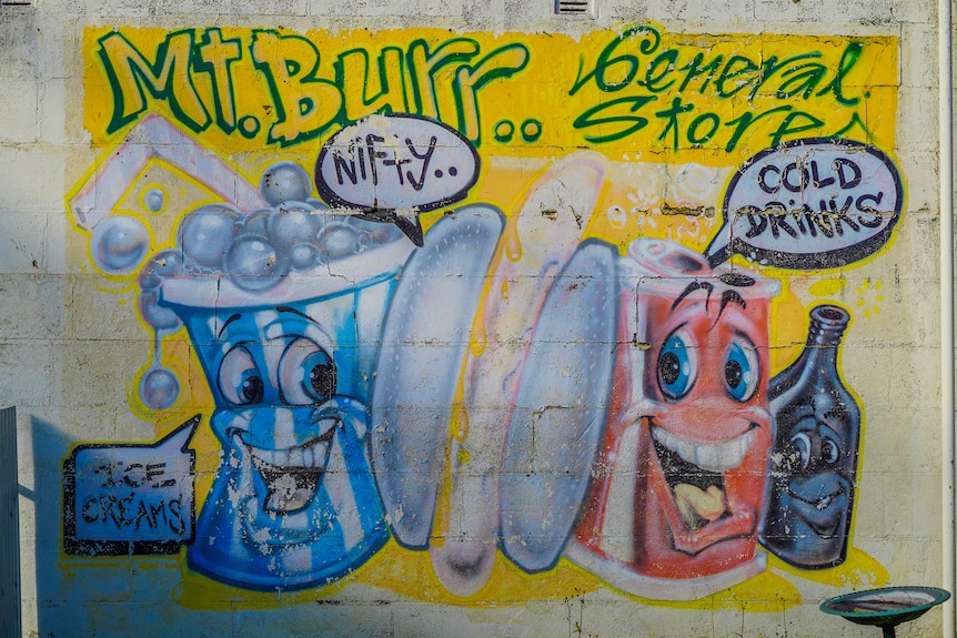 A colourful mural of a hotdog and soft drinks painted on a limestone wall.
