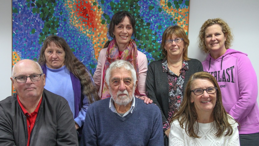 A group of seven people pose for the camera