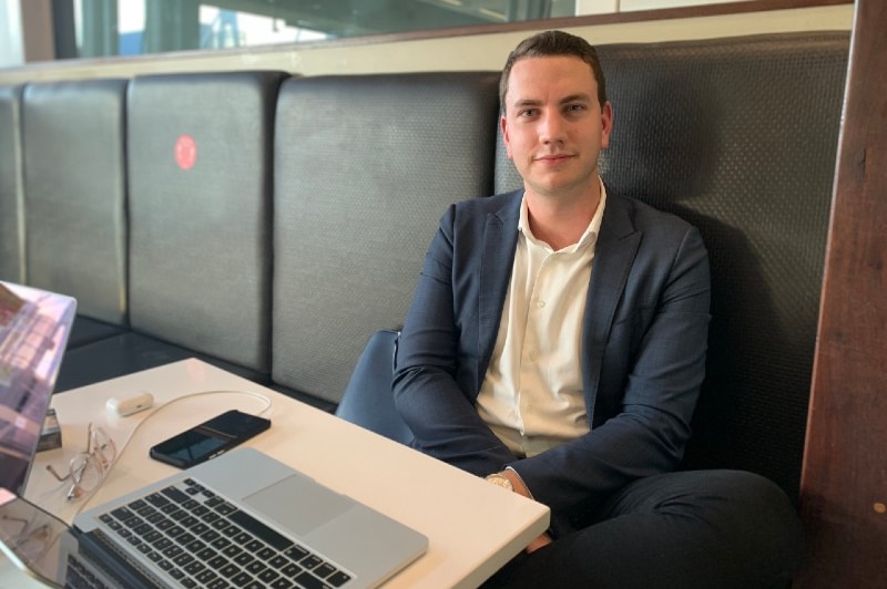 A man sitting at a table with a laptop.