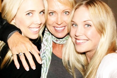 Three blonde women hug tight for a selfie group photo