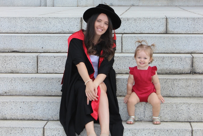 Dr Kristyn Sommer and her daughter sitting on some steps.