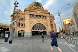 A man runs towards the steps at Flinders Street station.