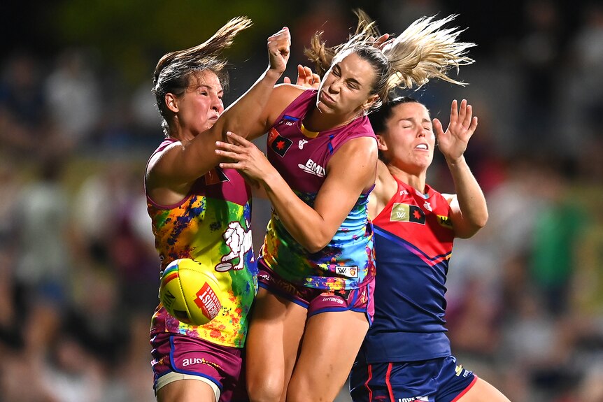 Lions and Demons AFLW players contest the ball in the air.