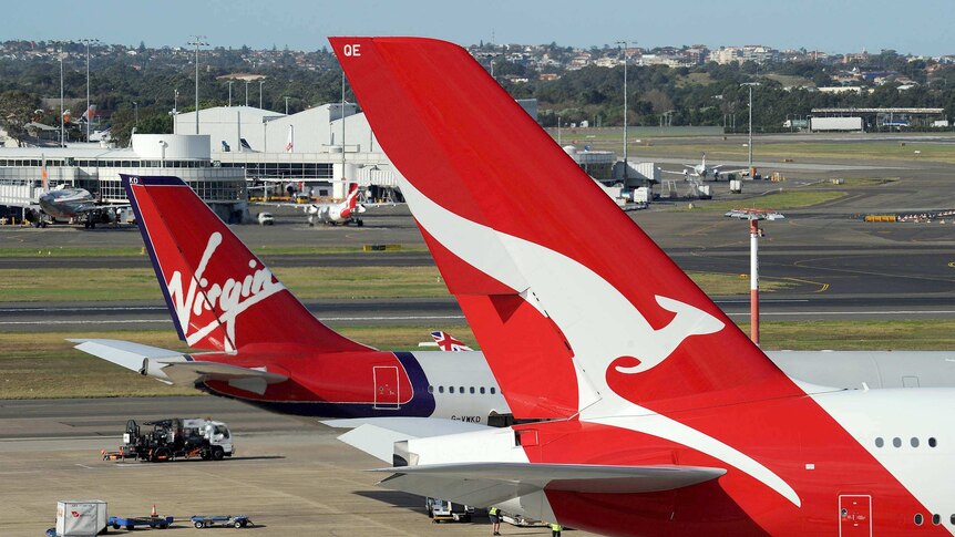A Qantas plane parked next to a Virgin plane