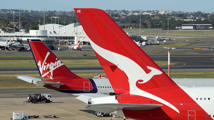 A Qantas plane parked next to a Virgin plane