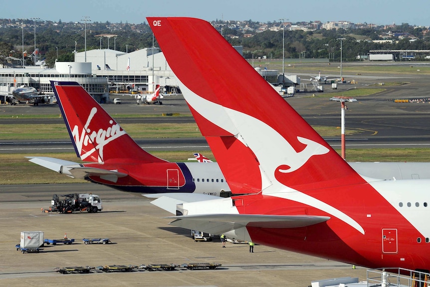 A Virgin plane parks next to a Qantas plane at Sydney's international airport on June 21, 2011.