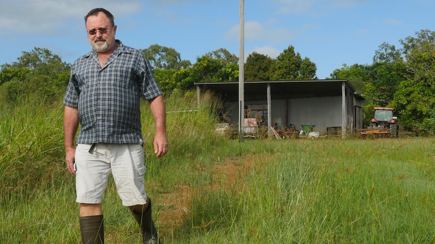  Wide shot of a bearded man walking away from a farm shed