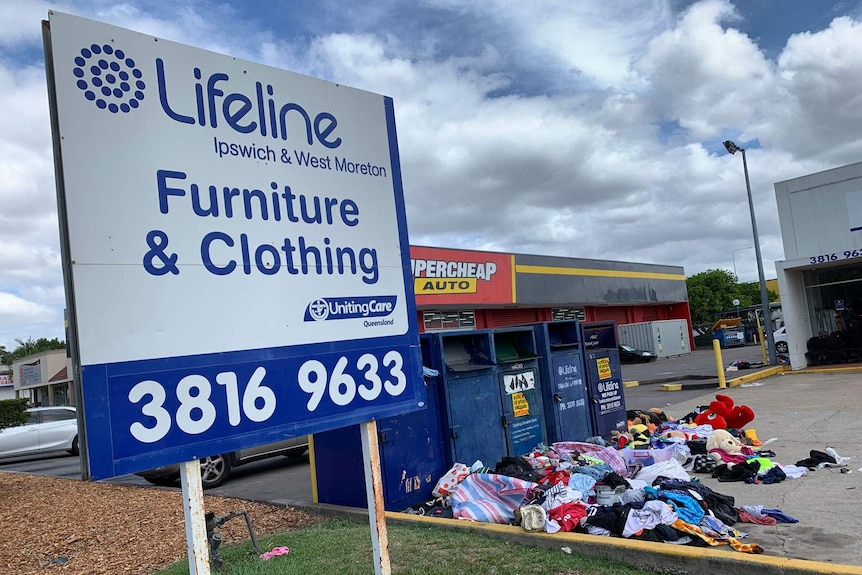 Lifeline sign in foreground with overflowing charity bins in background at Goodna.