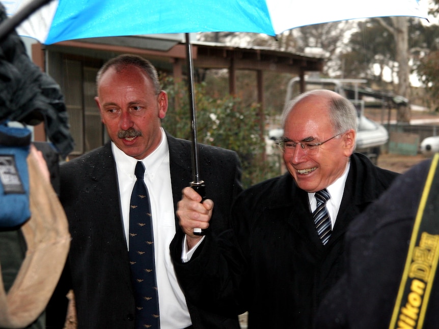 AFP officer Frank Morgan walks alongside then Prime Minister John Howard