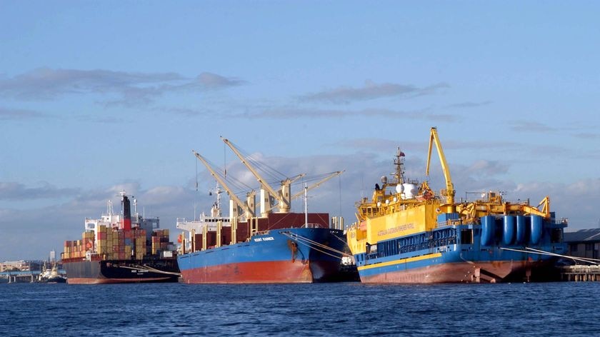 Three cargo ships lined up at dock at Fremantle Port.