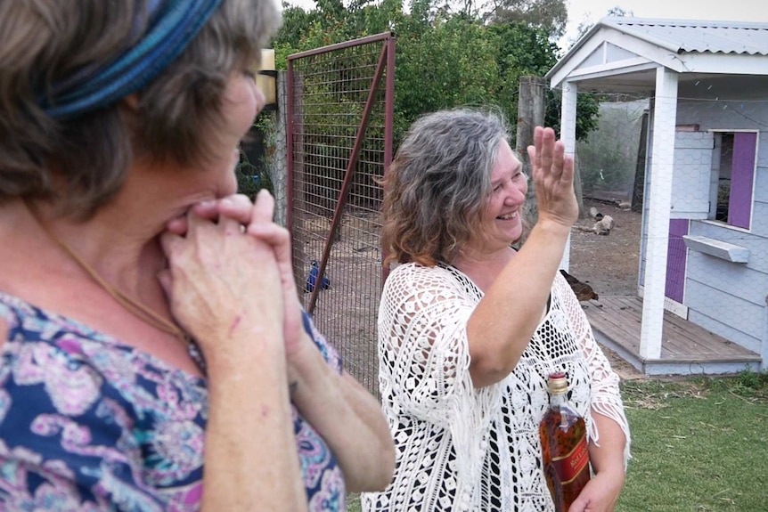 Two women wave goodbye