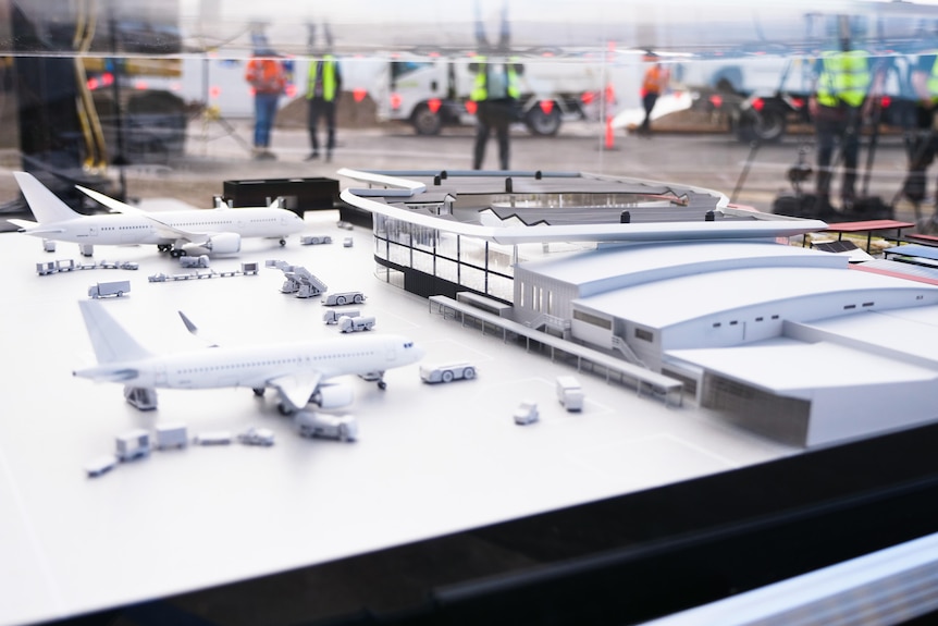 A model of an airport with a building and planes. 