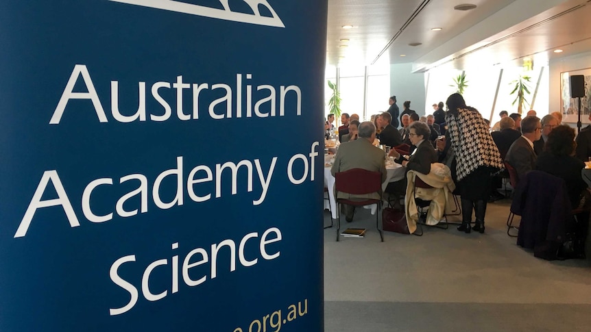 People sitting at tables at the Decadal Plan launch, with an Australian Academy of Science sign in the foreground.