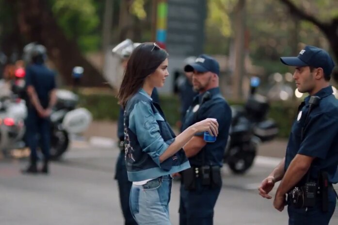 Kendall Jenner hands a police officer a can in a Pepsi ad.
