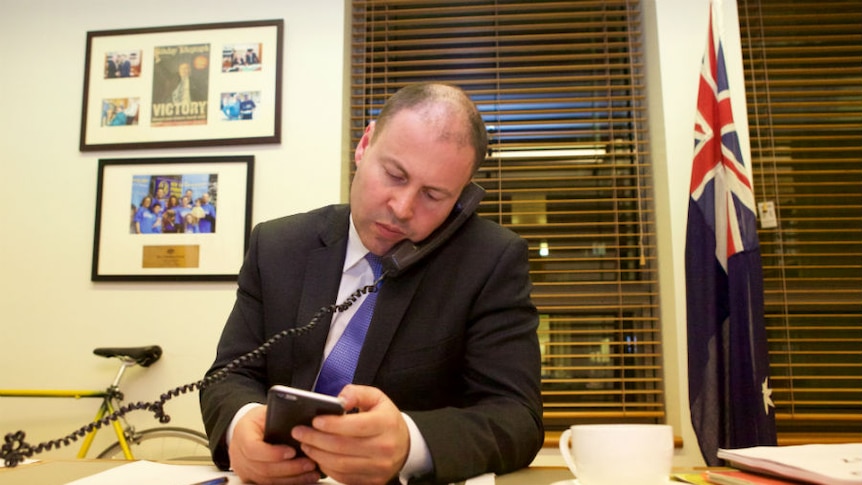 Minister for Energy and the Environment Josh Frydenberg talks on the phone in his office.