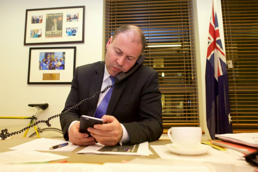 Minister for Energy and the Environment Josh Frydenberg talks on the phone in his office.