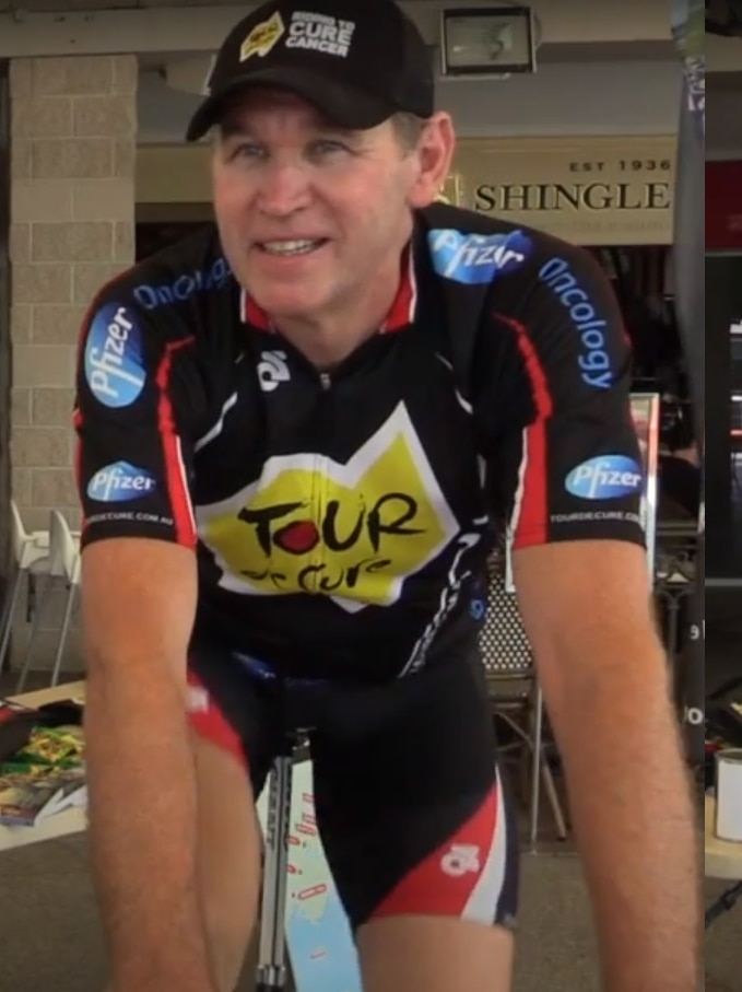 A man smiling while cycling on a bike