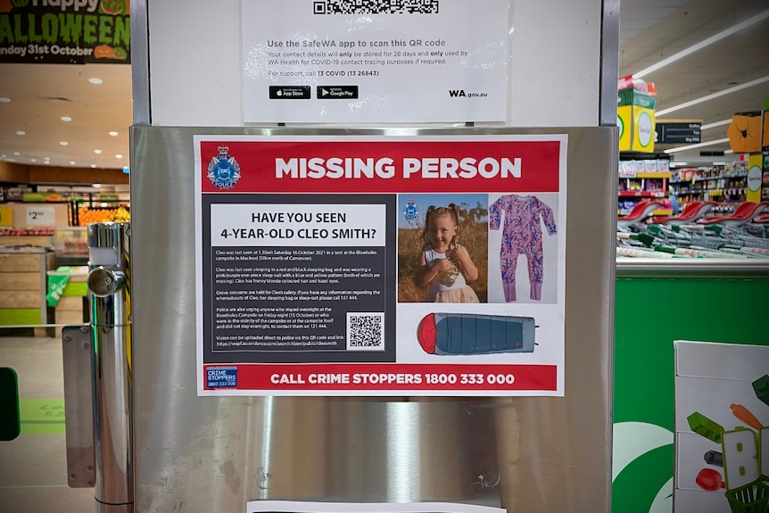 A Cleo Smith missing person poster on pole in a green themed supermarket