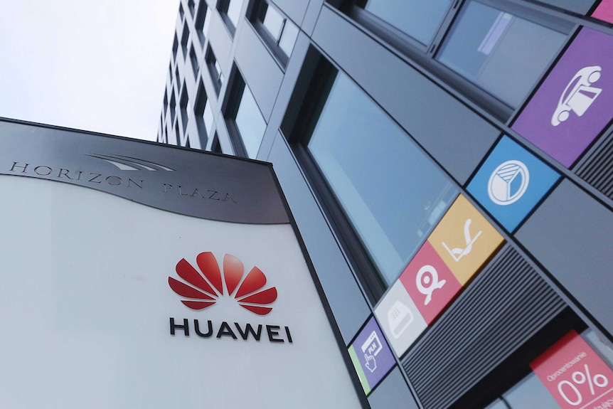 Красно-черный логотип Huawei отображается в головном офисе китайского технологического гиганта Huawei.