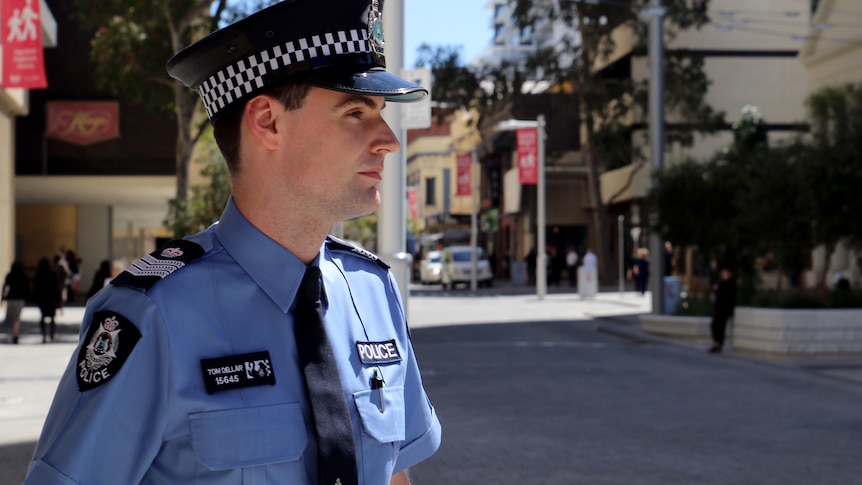 Sergeant Dellar crosses a street outside a court building.