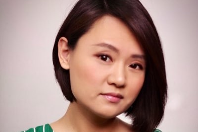 A young woman of Chinese appearance in a green and white striped shirt.