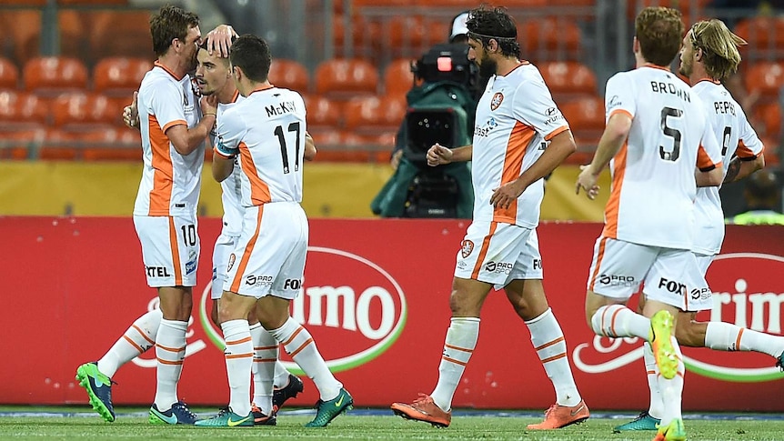 Jamie Maclaren of the Roar (second left) celebrates with team mates after scoring a goal