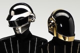 Two members of Daft Punk wearing shiny masks and one-piece jumpsuits with LED pinstripes