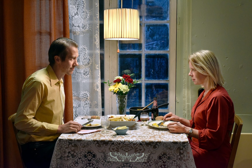 A film still of Jussi Vatanen and Alma Pöysti, seated opposite each other at the dinner table, eating a meal together.