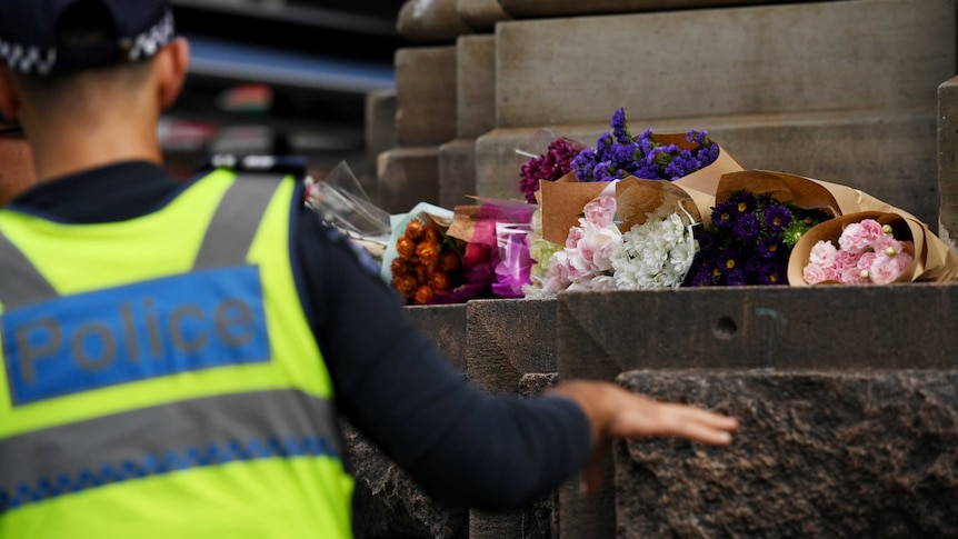 Police watch as mourners lay flowers in Bourke Street Mall