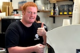 Man making coffee giving thumbs up to the camera